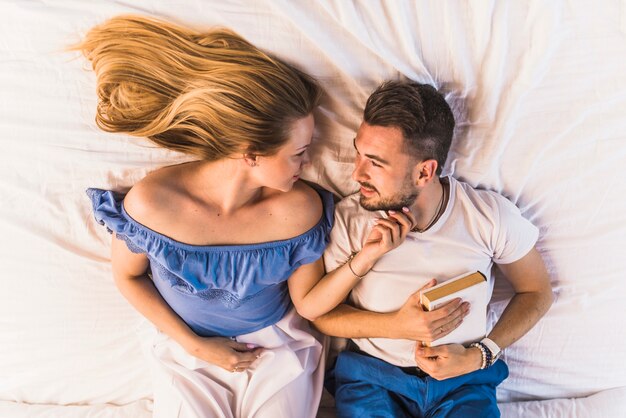 Free photo overhead view of lovely young couple lying on bed