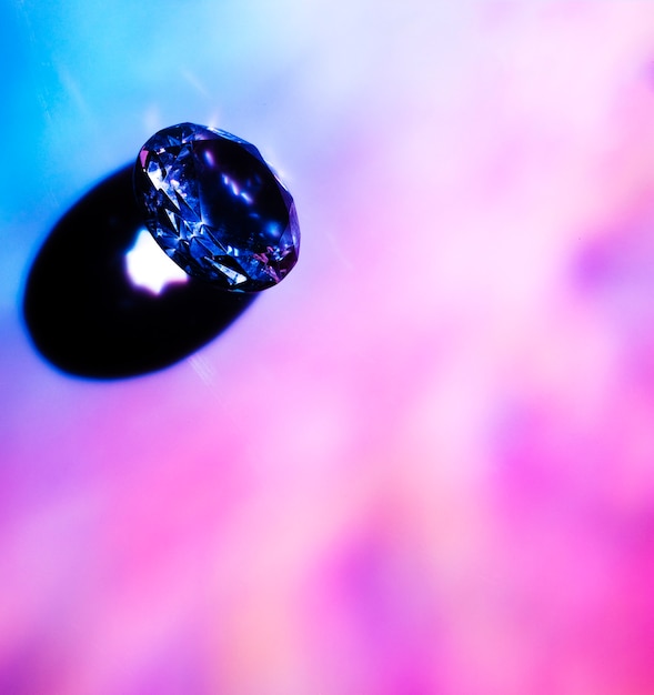 Free photo an overhead view of luxurious blue diamond shining on blur background