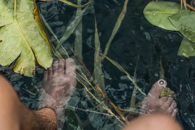 An overhead view of man's feet under the pond