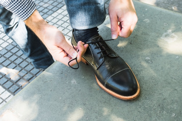 Free photo an overhead view of a man tying his shoelace