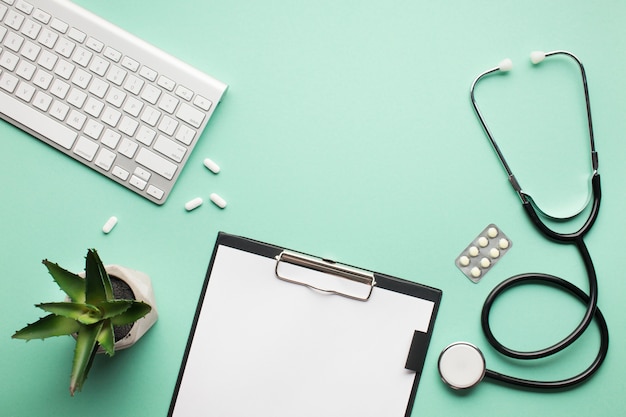 Free Photo overhead view of medical desk with succulent plant and wireless keyboard on green surface