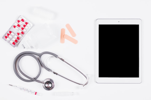 Free Photo overhead view of medical equipments with digital tablet on white backdrop