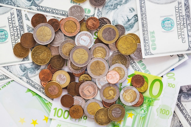 An overhead view of metallic coins over the spread euro banknotes