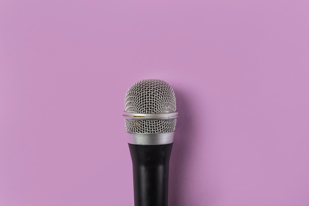 Free photo an overhead view of microphone on pink background