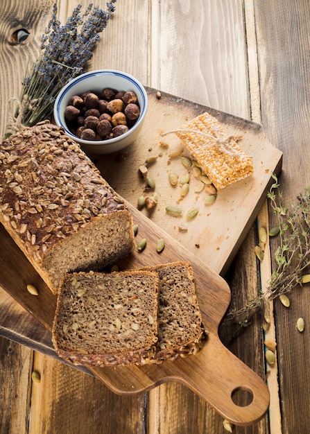 An overhead view of organic bread and energy bar on chopping board