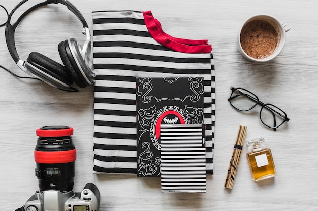 Overhead view of outfits with personal accessories on wooden desk