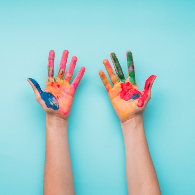 Overhead view of a painted hands on blue backdrop