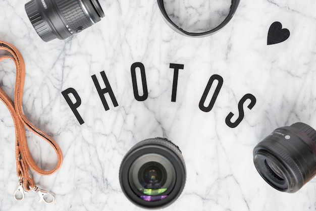 Overhead view of photos text surrounded with camera accessories and heartshape over marble background