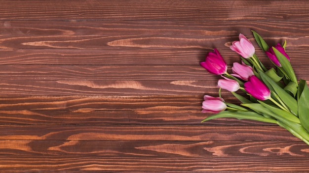 Overhead view of pink tulip flowers on wooden table