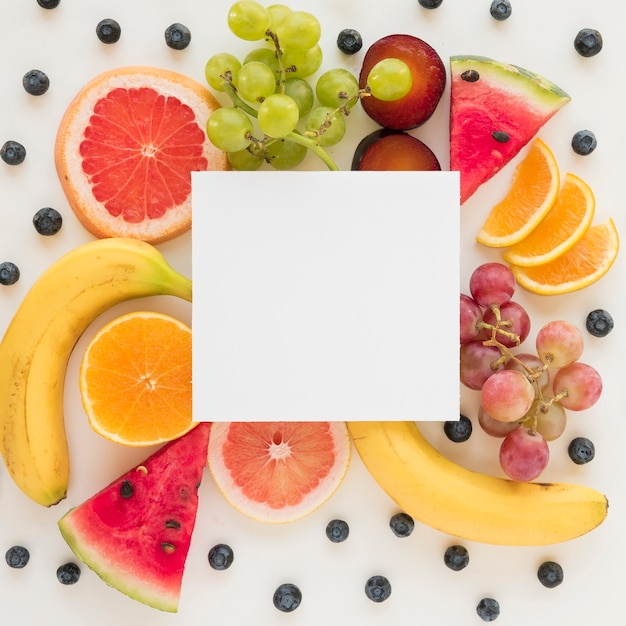 Free photo an overhead view of placard over the fresh healthy fruits on white backdrop