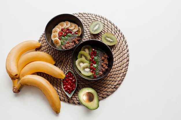 Free Photo overhead view on plate of green smoothie bowl topped with avocado and spinach , pomegranate seeds and granola.