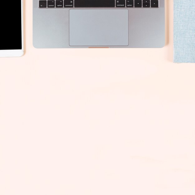 An overhead view of smart phone; laptop and diary on colored background