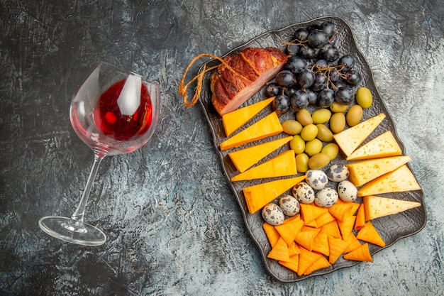 Free Photo overhead view of tasty best snack on a brown tray and fallen wine glass on ice background