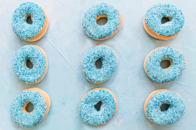 Free Photo overhead view of tasty donuts on blue background