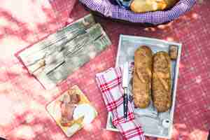 Free photo an overhead view of tray with bread; bacon; cheese on red cloth