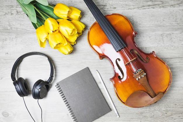 Free Photo overhead view of tulips; diary; pencil and violin on wooden background