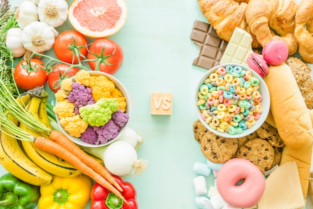 Overhead view of unhealthy versus healthy food over the background