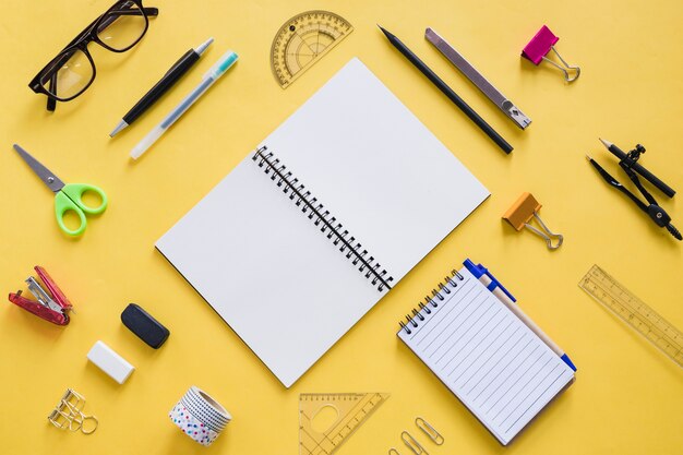 Overhead view of vivid stationeries on yellow backdrop