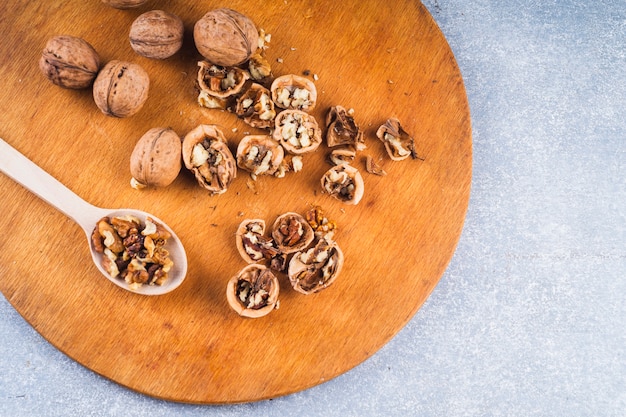 An overhead view of walnuts on wooden chopping board