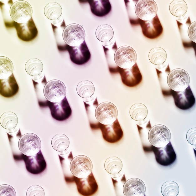 Free photo an overhead view of water glasses pattern on colored backdrop