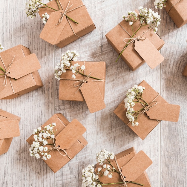 An overhead view of wedding gift boxes with baby's-breath flowers on wooden desk