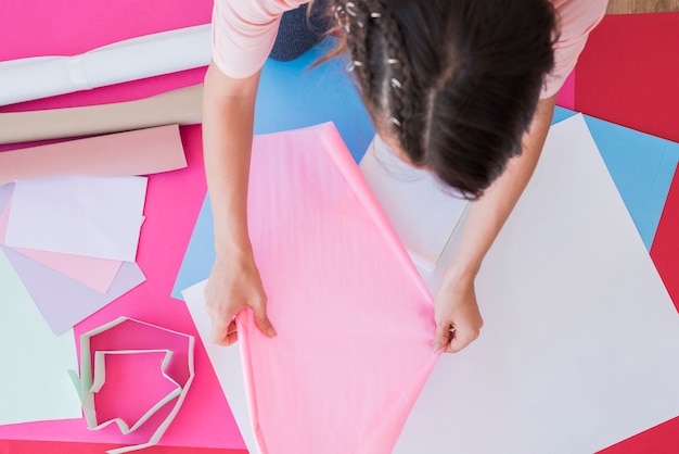 Free photo an overhead view of a woman holding pink card paper