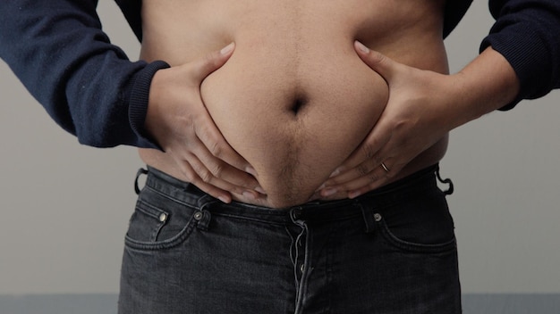 Free Photo overweight man closeup of belly front view put up shirt and pinch and clap a belly