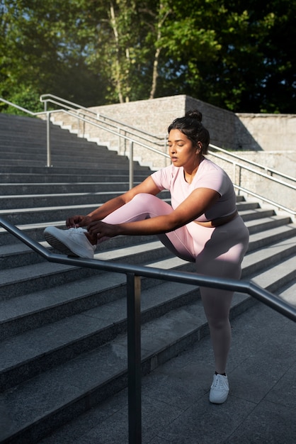 Free photo overweight woman exercising on stairs outdoors