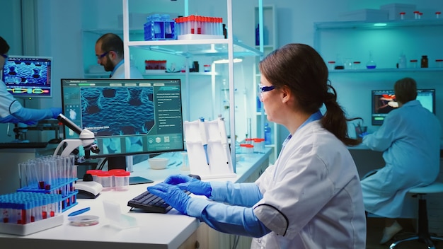 Free Photo overworked chemist sitting in modern equipped lab looking tired at camera