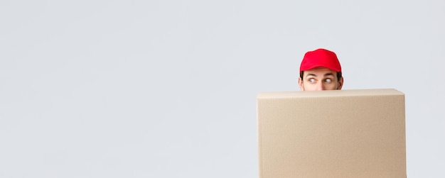 Packages and parcels delivery covid quarantine and transfer orders scared courier in red uniform cap...