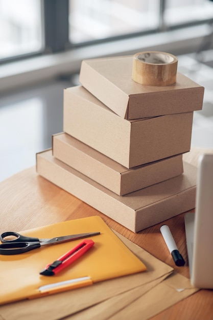 Free photo packages stacked on a round wooden office desk