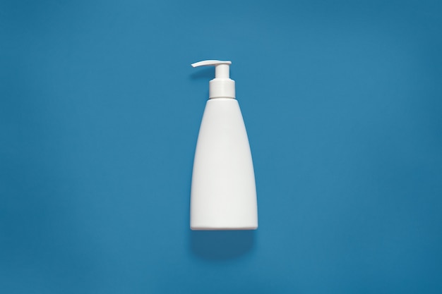 Free photo packing with liquid soap isoaltedon blue studio, cosmetic white empty plastic bottle with clipping path, front view of cosmetic container with copy space for advertisment. mock up.