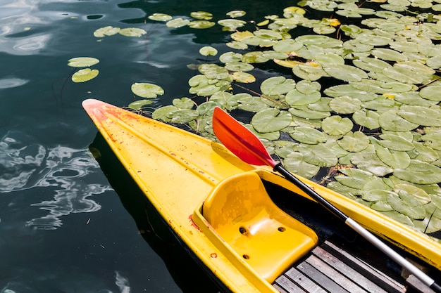 Free photo paddle oar in yellow canoe floating on lake