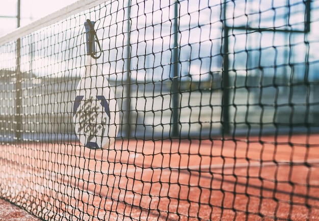 Padel blade racket hanging on the net