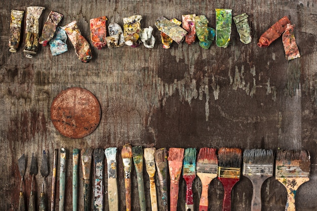 Free photo paint brushes and tubes of oil paints on wood