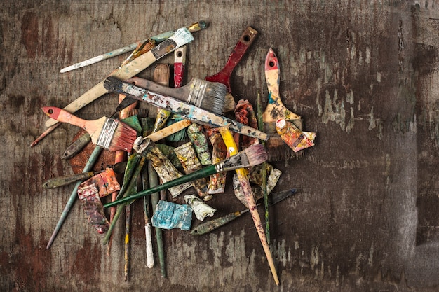 Free photo paint brushes and tubes of oil paints on wooden table