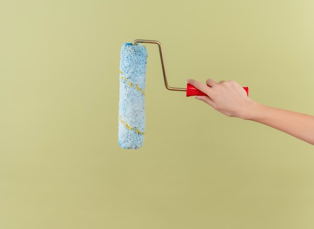 Paint roller on isolated green wall