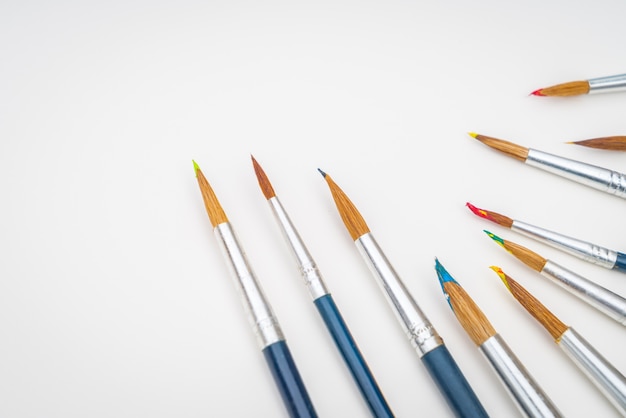 Paintbrushes with book on green grass