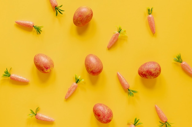 Free photo painted eggs and carrots on table