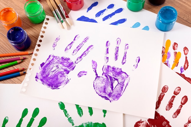 Free Photo painted handprints with artistic equipment 