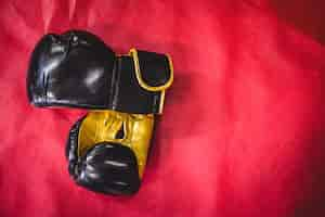 Free photo pair of boxing gloves on red surface