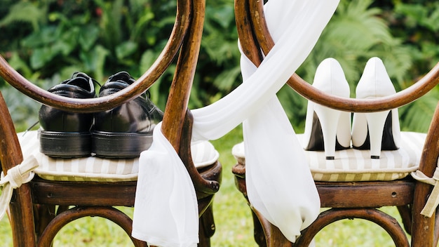 Pair of wedding shoes on wooden chair in the park