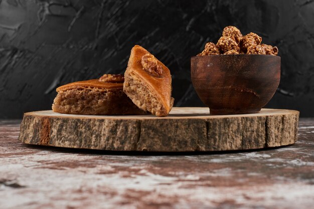 Pakhlava and nuts on a wooden board.