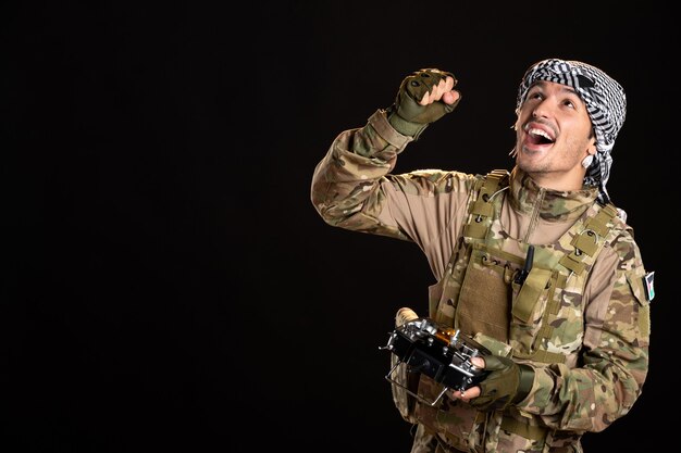 Palestinian soldier using remote controller on black wall