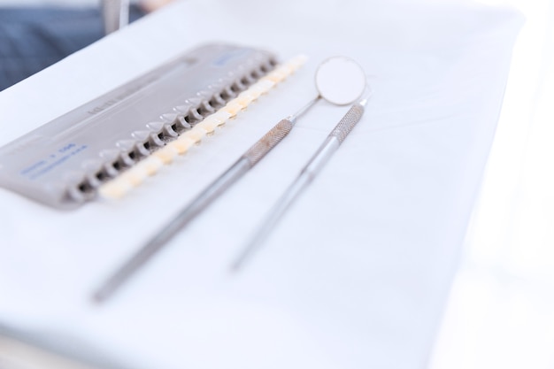 Free photo palette of teeth shades with dental mirror and probe on desk