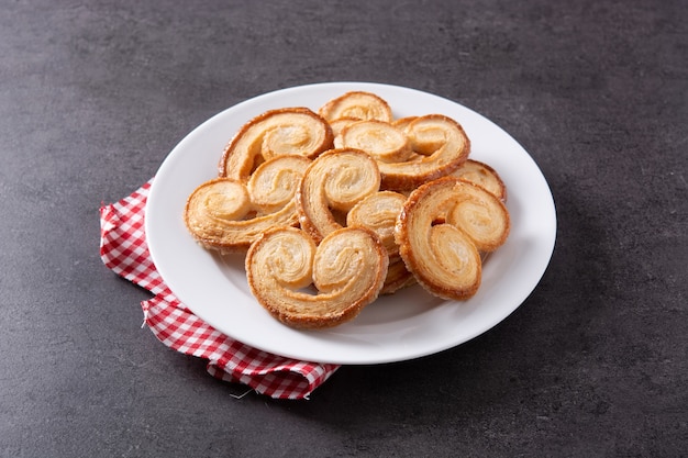 Palmier puff pastry in plate on black slate background