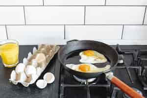 Free photo pan with fried eggs and orange juice