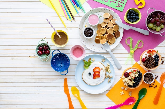 Free photo pancake party, kids food with fresh berries and yogurt