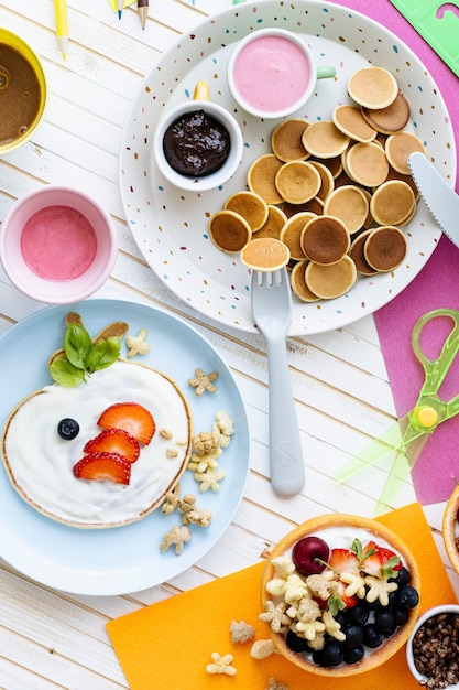 Free photo pancake party, kids food with fresh berries and yogurt