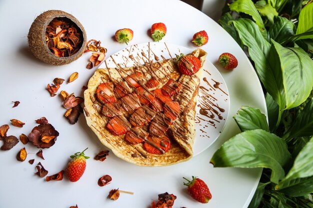 Pancake topped with strawberry slices and chocolate